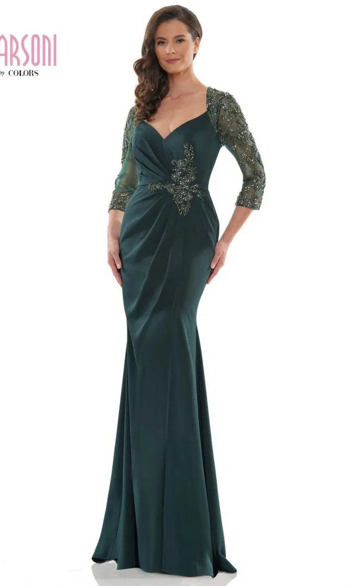 A woman wears the Marsoni MV1070 Long Formal Dress in deep green, featuring beaded three-quarter sleeves, a decorative waist detail, and a softly draped bodice.